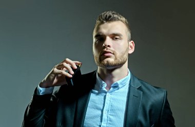 Parfüm lüzfünü. Bir şişe parfümeri tutan adam. Mans parfüm konsepti. Erkekparfüm.