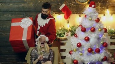 Adam yardım kızlar gözlerle kapatır ve onu bir hediye sunmak. Yeni yıl hediyesi çok hoş bir kız. Yeni yıl ruh hali.