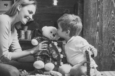 Anne ve teddy ile oynayan çocuk gülümseyen portre. Sevimli küçük çocuk oyuncak ayı içinde mavi ve kırmızı pijama öpüşme. Çok güzel çocuk Oluşturucu, plastik blok yeşil ve kırmızı parçalarını tutar