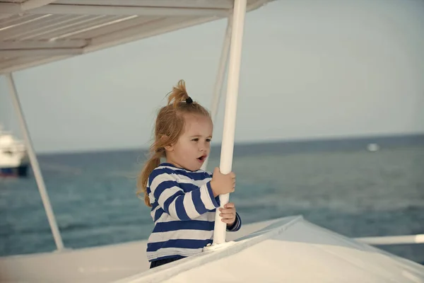 Enfant en chemise rayée bleue et blanche sur yacht . — Photo