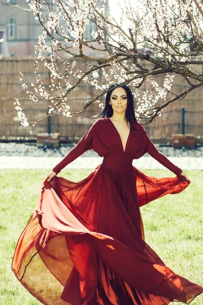 Menina em vestido vermelho perto de flor — Fotografia de Stock