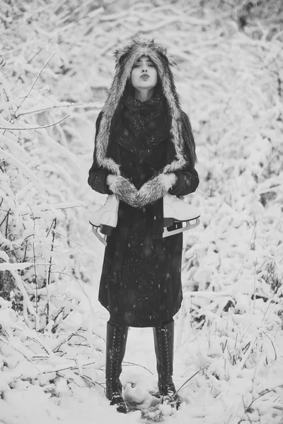 Γυναίκα με παπούτσια πατινάζ σε ρούχα του χειμώνα στο χιονισμένο δάσος — Φωτογραφία Αρχείου
