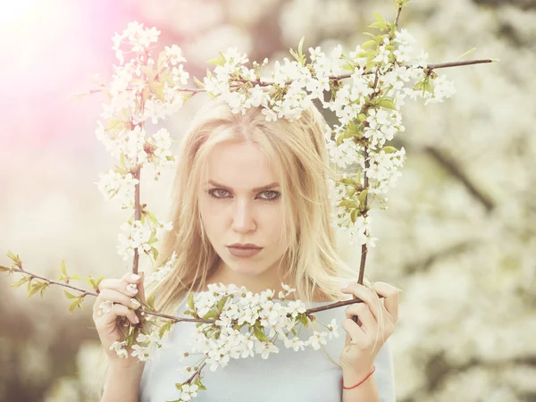 Porträtt av flicka med allvarliga ansikte poserar med blomma ram — Stockfoto