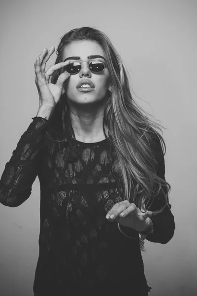 Mujer sexy de moda con pelo largo con top de encaje y gafas de sol. Hermosa mujer joven en top de encaje con labios sensuales tocando gafas de sol, fondo gris. Concepto de gafas graduadas . — Foto de Stock