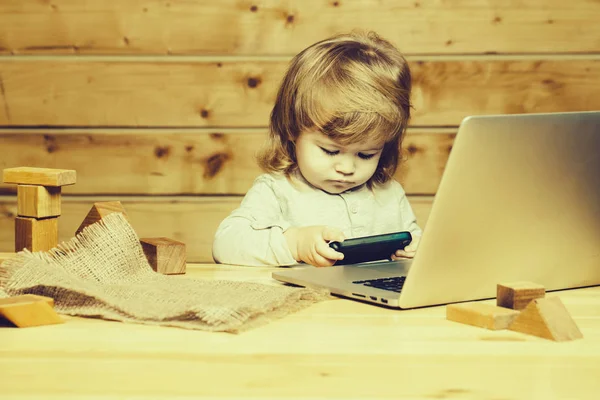 Menino pequeno com computador e telefone — Fotografia de Stock