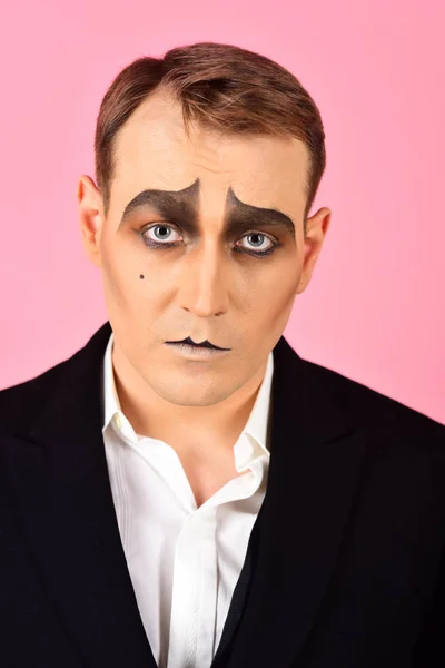 Tragical actor. Man with mime makeup. Mime artist. Mime with face paint. Theatre actor miming. Stage actor miming. Theatrical performance art and pantomime. Comedian or tragedian performer