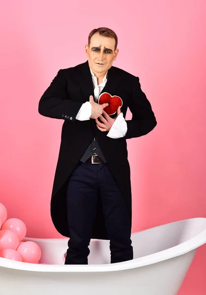 Happy valentines day. Mime actor has valentines celebration party. Mime man celebrate valentines day. Comedian actor hold red heart in bath. Being hopelessly in love performance