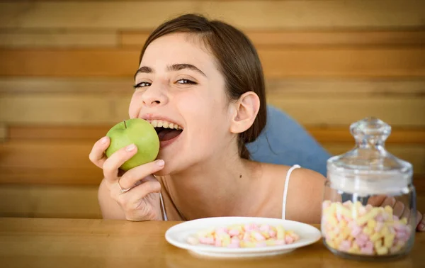 Say no to unhealthy food. Woman choose what food to eat. Organic and natural or sweet and unhealthy. Vitamin or sugar. Dietetic or unhealthy food. Pretty woman prefer apple to marshmallows — Stock Photo, Image