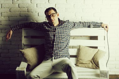 adam gözlük ve mikrofon ile bankta kareli gömlek