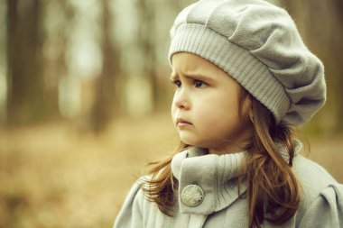 Palto ve şapka ayakta sonbahar ormandaki küçük kız. hildhood, açık yürüyüş