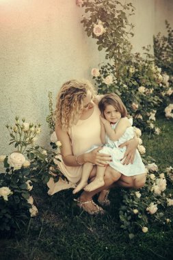 Yeşil çimenlerin üzerinde anne sarılma kızı