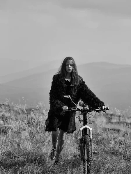 Дівчина з велосипедом на горі — стокове фото