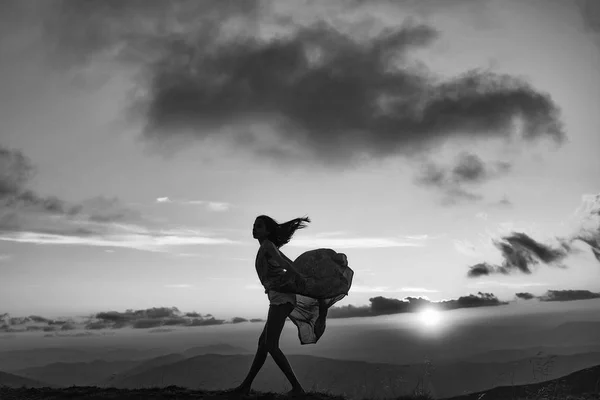 Frau bei Sonnenuntergang oder Sonnenaufgang in den Bergen — Stockfoto