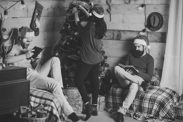 Hombres y mujeres de Navidad leen el libro en el árbol . — Foto de Stock