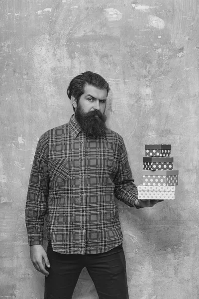 Ciddi sakallı adam renkli hediye kutuları tutarak ellerinde yığılmış — Stok fotoğraf