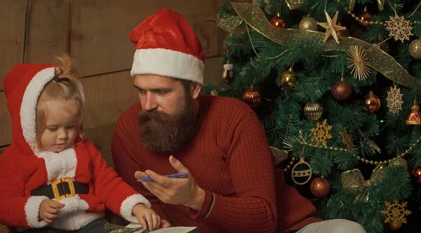 Papai Noel criança e homem barbudo na árvore de Natal . — Fotografia de Stock