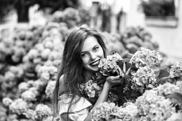 Красива усміхнена дівчина в квітах гортензії — стокове фото