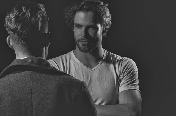 Двое красивых мужчин стоят напротив
