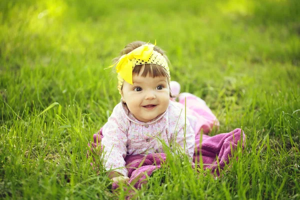 Niedliches kleines Mädchen auf grünem Gras — Stockfoto