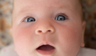 Kanepede kaynıyor. Mutlu küçük çocuk portresi. Tatlı küçük bebek. Yeni yaşam ve Bebek Doğum. Aile. Çocuk Bakımı. Çocuk günü. Sevimli yüzü olan küçük kız. ebeveynlik. Çocukluk ve mutluluk