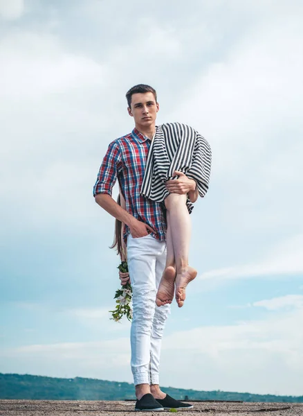 El hombre lleva a una chica en el cielo. caminando al aire libre. cansado después de un día agotador. viajes de senderismo. pareja enamorada. pareja joven al aire libre. hombre y mujer en camino. Ella es mi presa. Problemas en las relaciones —  Fotos de Stock