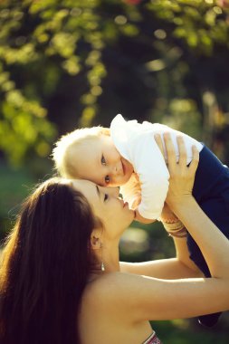 Mutlu sevimli bebek çocuk, küçük, küçük, oğlu ve güzel anne, kadın, eğleniyor, uzun saçlı, gülümseyen güneşli yaz doğa doğal zemin üzerine açık havada. Anneler günü, aile sevgisi