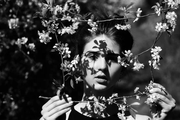 Mädchen mit Rahmen aus blühenden Blumen im Frühlingsgarten — Stockfoto