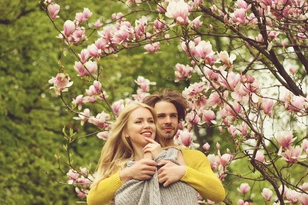 Κοπέλα και άντρας, ζευγάρι στην αγάπη στην άνοιξη του magnolia λουλούδια — Φωτογραφία Αρχείου