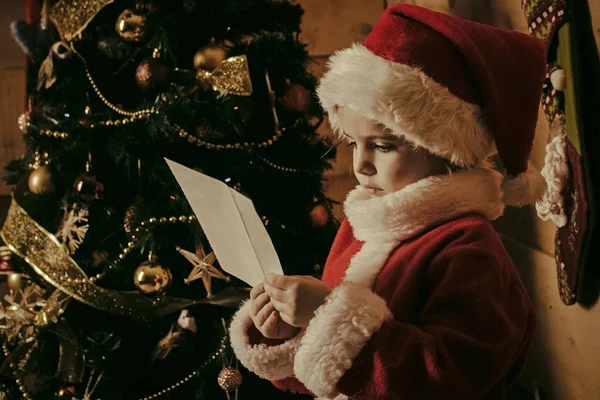 Weihnachtsmann-Kind am Weihnachtsbaum. — Stockfoto