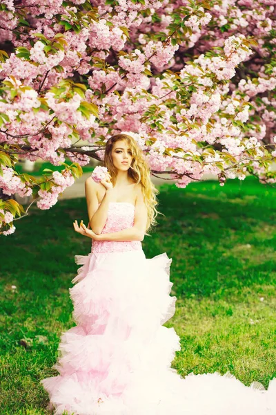 Mujer en vestido rosa cerca de la floración —  Fotos de Stock