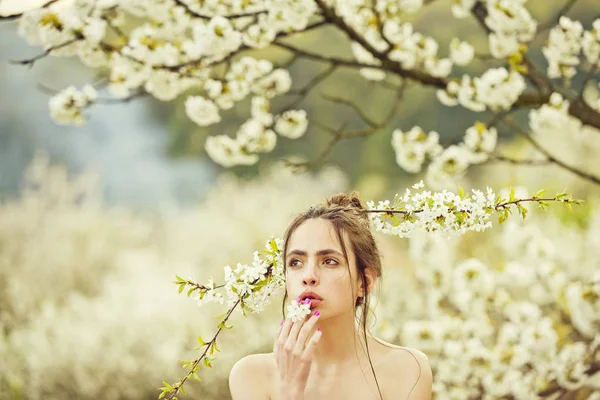 Flicka innehav vit, blommande blommor i mun och hår — Stockfoto