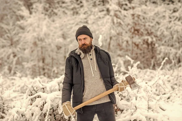 Taglialegna uomo barbuto tenere ascia nella foresta invernale innevata, campeggio — Foto Stock