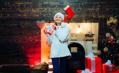 Noel iç. Noel Baba kostüm komik kız. Noel ağacı ile kapalı kız moda portre. Şehvetli kız Noel için. Ev tasarımı üzerinde Santa şapkalı güzellik modeli kız süslemek.