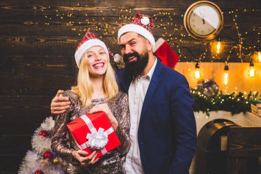 Yılbaşı süsleri ve hediye kutusu ahşap arka plan üzerinde. Sürpriz ve komik bir çift portresi. Noel çift aşık.