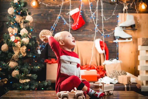 Szczęśliwe dziecko z świąteczny prezent na podłoże drewniane. Szczęśliwy, że małe dzieci w santa hat z obecnie mają Bożego Narodzenia. Koncepcja wakacje zima święta Bożego Narodzenia. Dzieci. — Zdjęcie stockowe