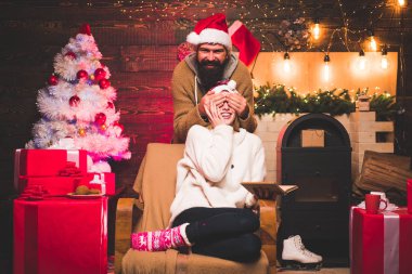 Etkin çiftler Noel kutlaması. En büyük aşk hikayeleri. Güzel çift bir Santa şapka giymiş. Yakışıklı sakallı hippi Santa gülümseyen pozitif genç kadınla.