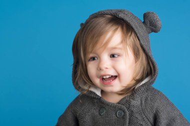 çocukluk ve mutluluk. küçük mutlu kız. küçük kız çocuk gülümseyen. sonbahar ve ilkbahar moda evlat. eğleniyor. Küçük müzisyen. mavi arka plan üzerinde gülümseyen çocuk