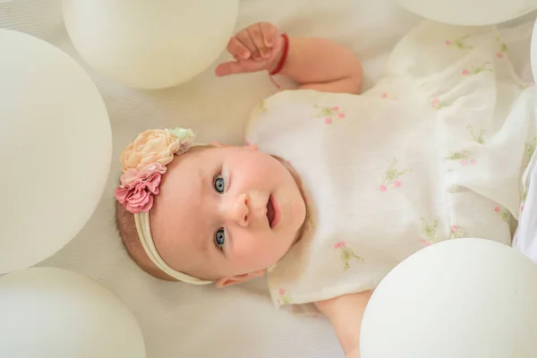 Baby care. Sweet little baby. New life and birth. Small girl. Happy birthday. Family. Child care. Childrens day. Portrait of happy little child in white balloons. Childhood happiness