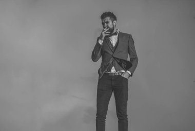 Adam sakal ve arka plan üzerinde dramatik gökyüzü ile sigara.