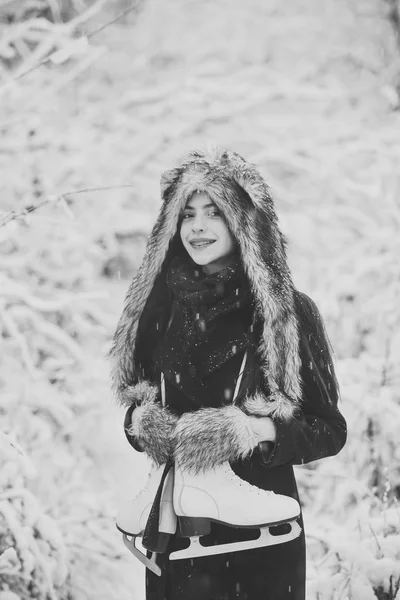 Fille sourire avec patins artistiques aux arbres dans la neige — Photo