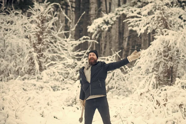 Bebaarde man met bijl in het besneeuwde forest. — Stockfoto