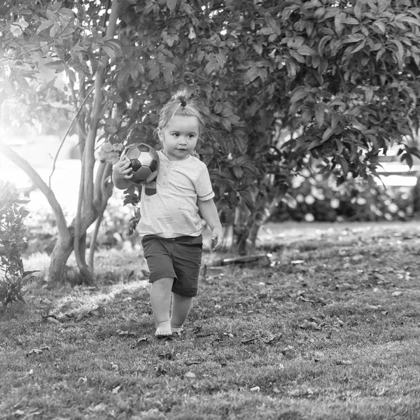 Χαριτωμένο μωρό αγόρι παίζει με μπάλα για την πράσινη χλόη — Φωτογραφία Αρχείου