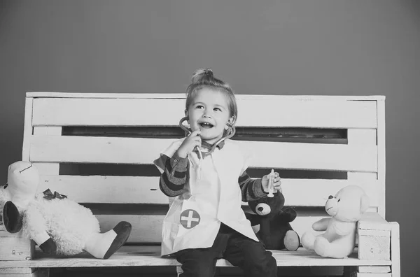 快乐的婴儿在兽医医生制服与玩具宠物坐在木凳上的蓝色背景 兽医诊所游戏 未来行业理念 — 图库照片