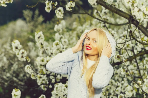 Kvinna med röda läppar och blonda hår i blossom — Stockfoto