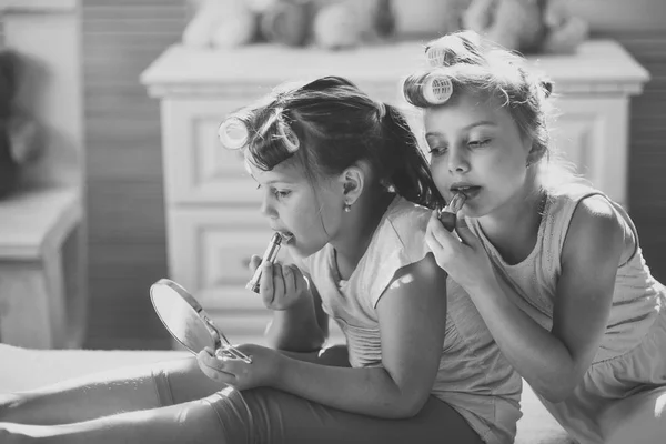 Little girls do makeup sitting in room with toys — Stock Photo, Image