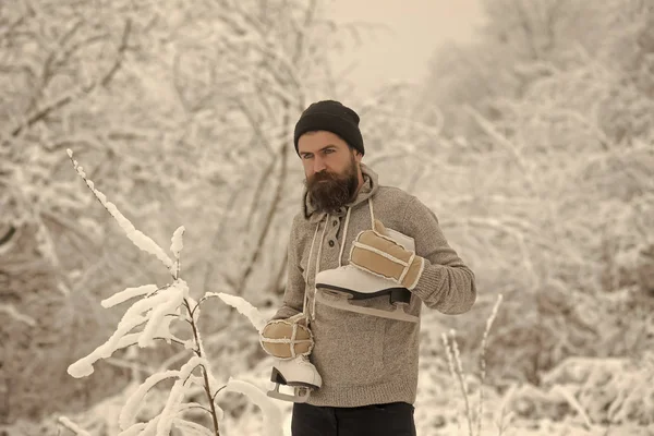 Sakallı adam paten karlı ormandaki ile. — Stok fotoğraf