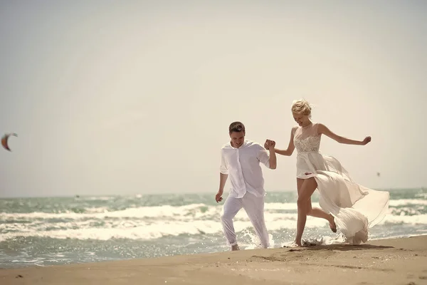 Смеющаяся свадебная пара на пляже — стоковое фото