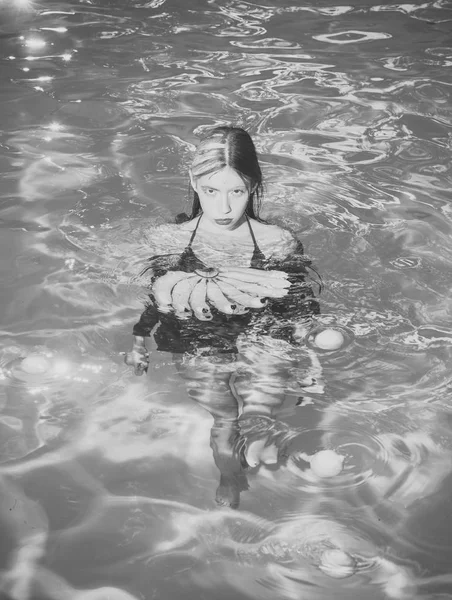 Vitamin in Banane bei Mädchen, die am Wasser sitzen. Frau mit tropischen Früchten im Pool. Frau entspannen im Wellness-Pool. Sommerurlaub und Reise ans Meer. Diät und gesunde Biolebensmittel, vegetarisch. — Stockfoto