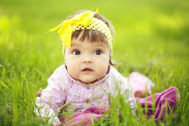 Yeşil çimenlerin üzerinde şirin bebek kız