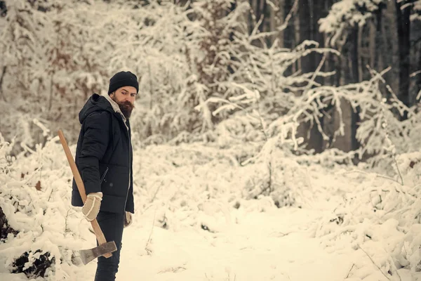 Sakallı adam karlı ormanda balta ile. — Stok fotoğraf